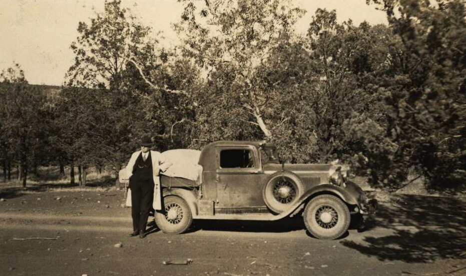Australian Inland Mission Southern Patrol car with Reverend John Flynn leaning against the back tray